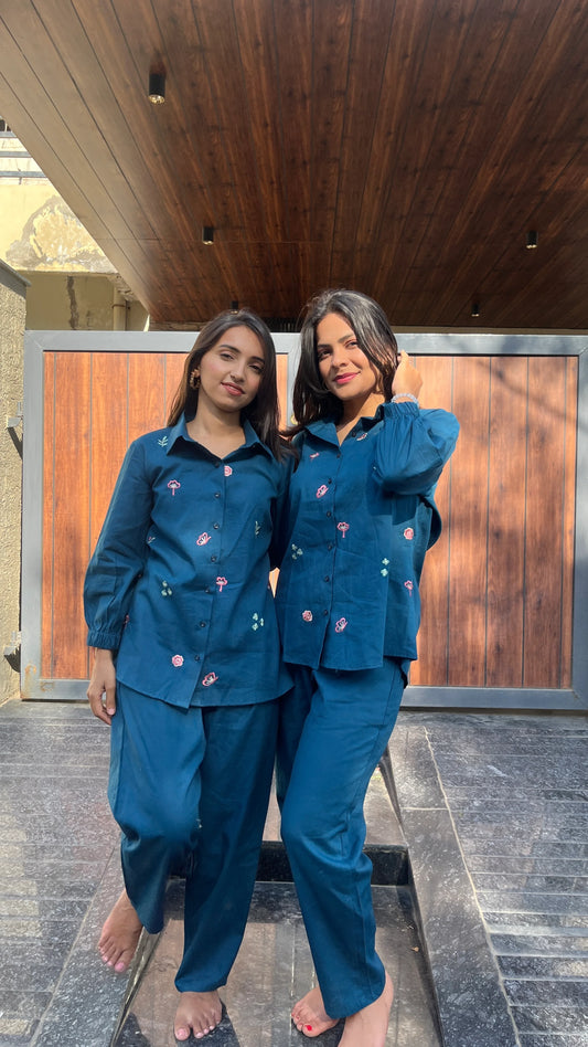 Two women wearing Urrva's Neelphool indigo co-ords with floral embroidery – cotton shirt and pants set