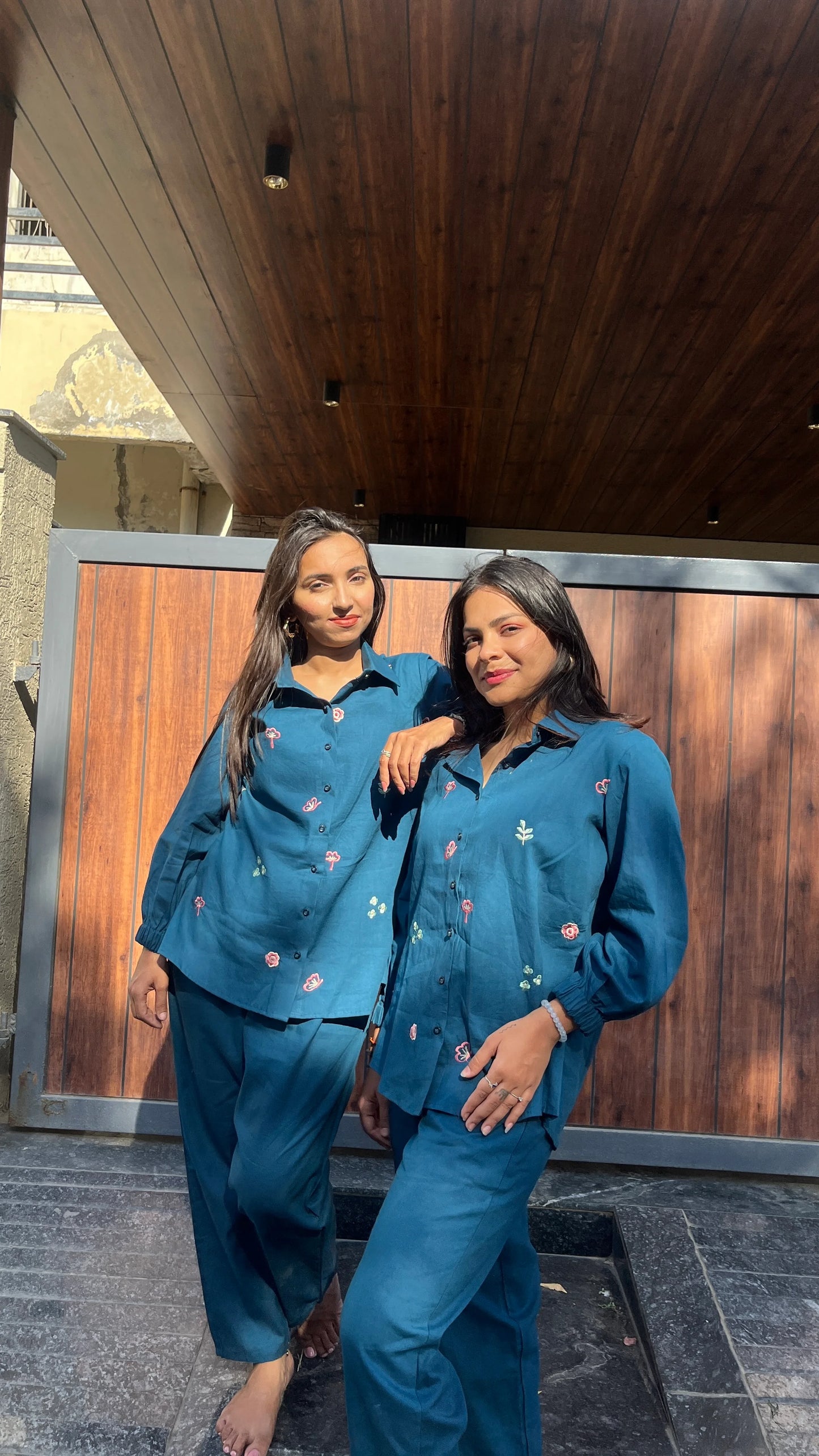 Two women wearing Urrva's Neelphool indigo co-ords with floral embroidery – cotton shirt and pants set